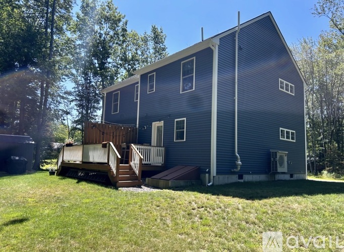 A house with a blue exterior and a deck in front.