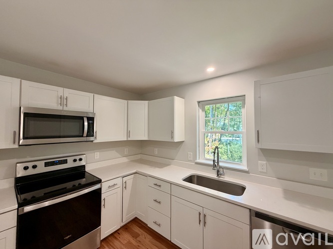 A kitchen with white cabinets and a black stove top oven.