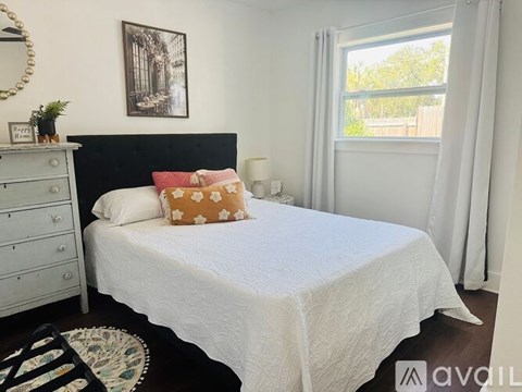 A bedroom with a white bed and a black headboard.