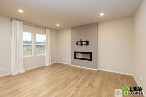 A spacious room with a fireplace and large windows.