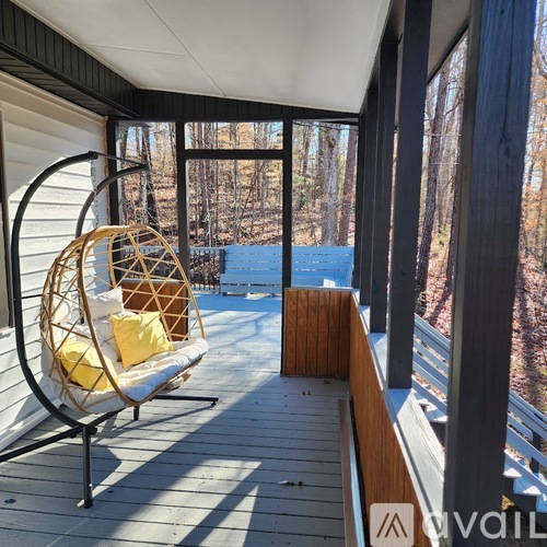 A white chair with a yellow cushion is on a wooden deck.