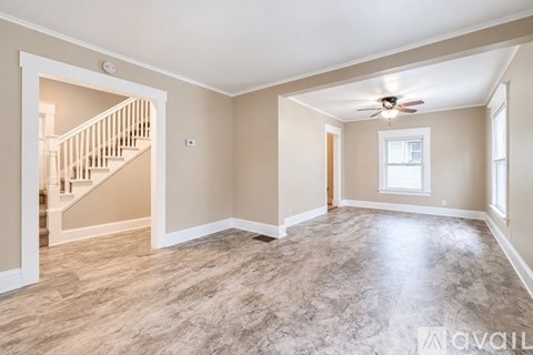 A spacious room with a staircase leading to the upper floor.