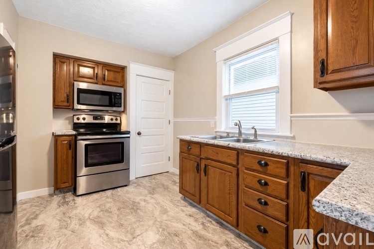 A kitchen with wooden cabinets and granite countertops.