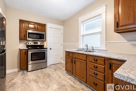 A kitchen with wooden cabinets and granite countertops.