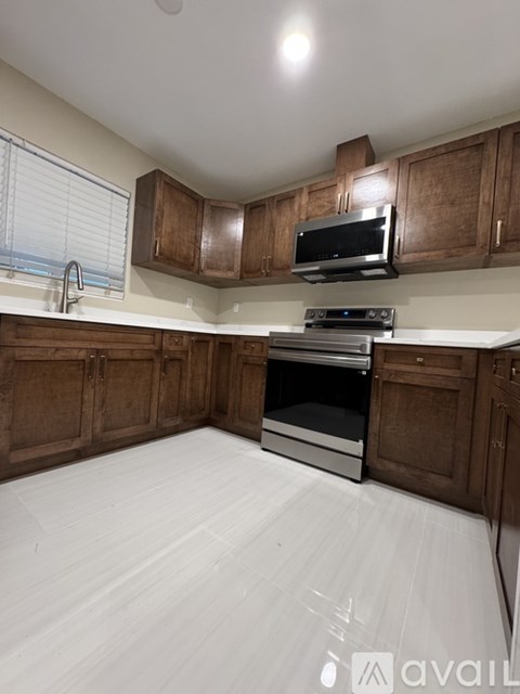 A kitchen with wooden cabinets and a stainless steel oven.