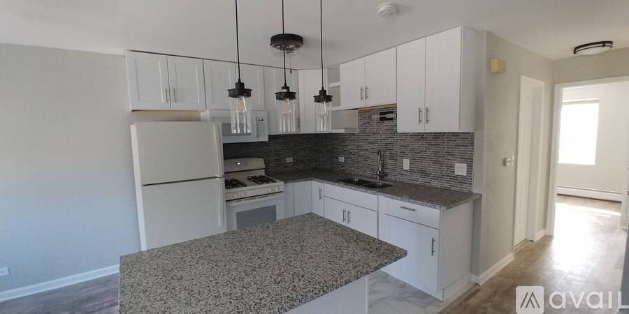 A kitchen with granite countertops and white cabinets.