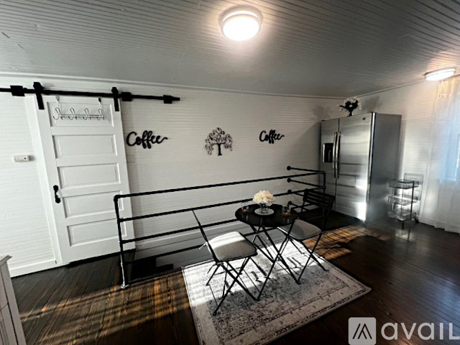 A small room with a table and chairs and a sign that says "Coffee".
