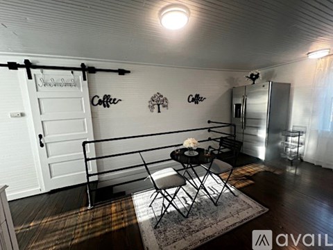 A small room with a table and chairs and a sign that says "Coffee".