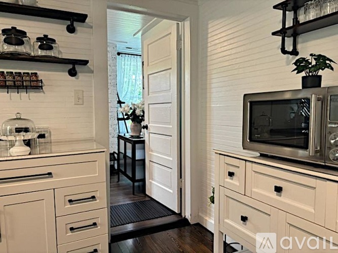 A kitchen with a microwave on top of the counter.