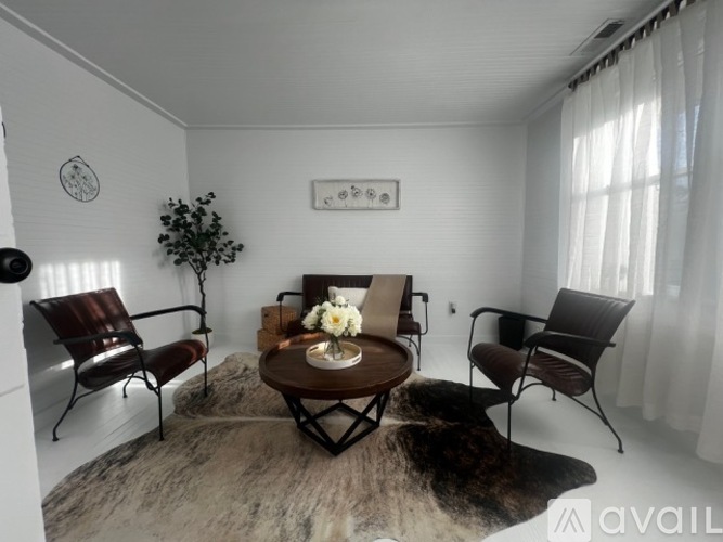 A living room with a brown chair, a brown sofa, and a brown coffee table.