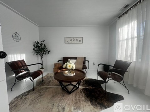 A living room with a brown chair, a brown sofa, and a brown coffee table.