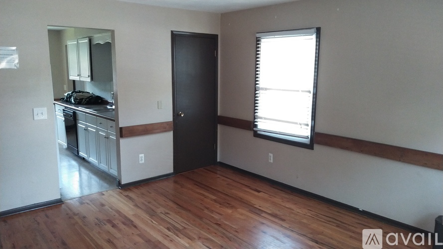 A room with wooden floors and a black door.