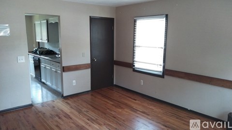 A room with wooden floors and a black door.