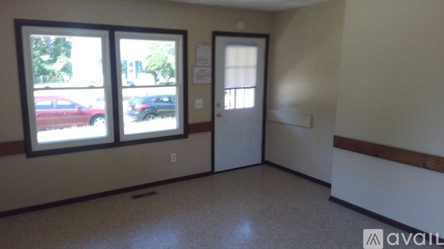 A room with a door, two windows and a wall socket.