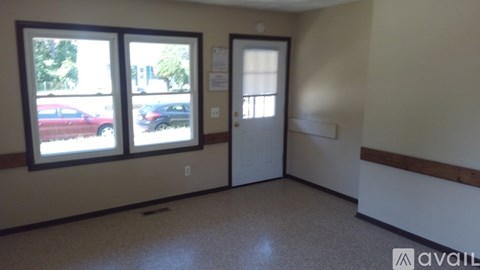 A room with a door, two windows and a wall socket.
