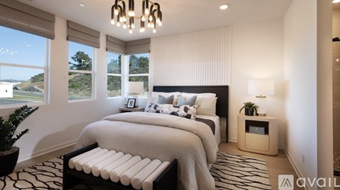 A bedroom with a large bed and a view of the outdoors through the window.
