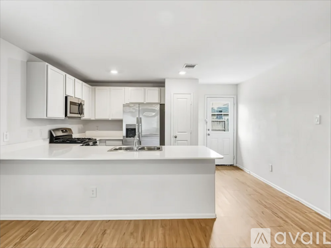 A modern kitchen with white cabinets and a white island.