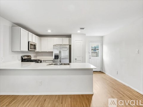 A modern kitchen with white cabinets and a white island.