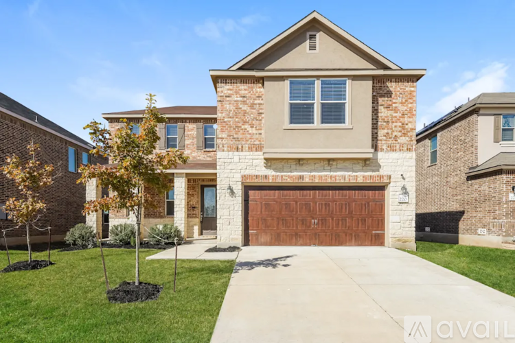 A house with a garage door and a driveway in front.