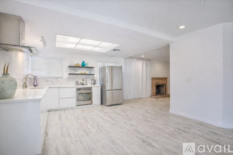 A modern kitchen with white cabinets and stainless steel appliances.