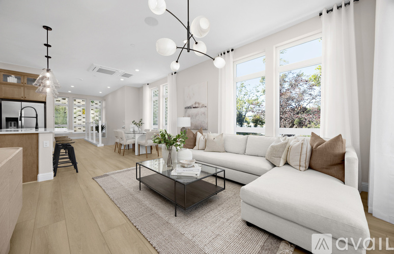 A modern living room with a white sofa and a glass coffee table.