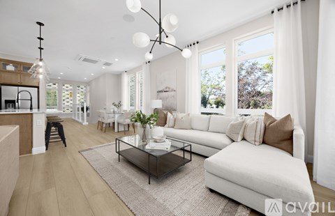 A modern living room with a white sofa and a glass coffee table.