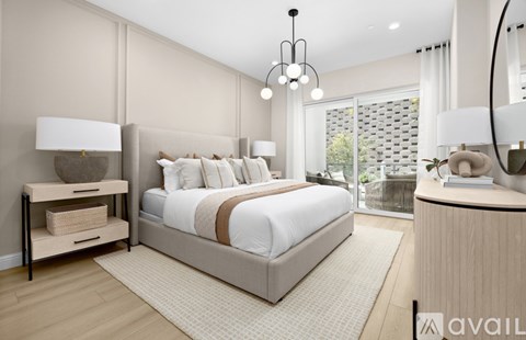 A well-lit bedroom with a large bed and a mirror on the dresser.