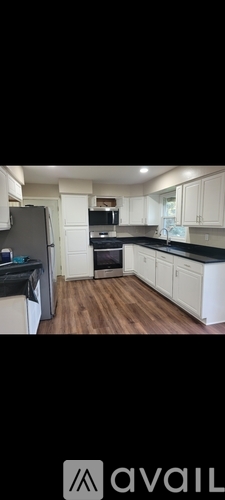 A kitchen with white cabinets and a black countertop.