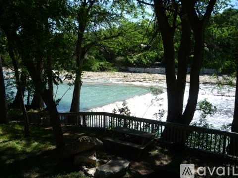 A view of a river from a bridge with trees on either side.