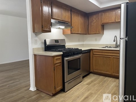 A kitchen with wooden cabinets and a black fridge.