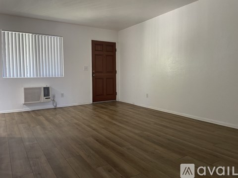 A room with wooden flooring and a brown door.