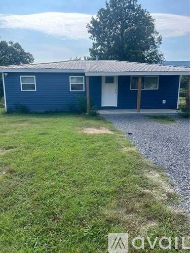 A blue house with a gravel path leading to the front door.