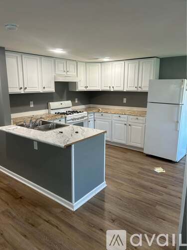 A kitchen with white cabinets and a white refrigerator.