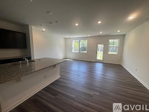 A spacious room with wood flooring and a countertop.