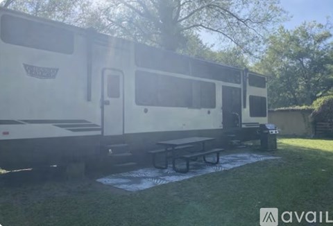 A white RV is parked in a grassy area.