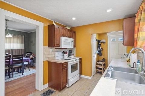 A kitchen with a white oven and a white microwave.