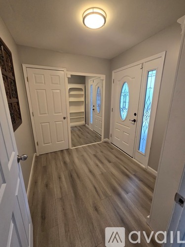 A hallway with wooden floors and white doors.