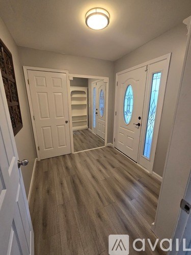 A hallway with wooden floors and white doors.