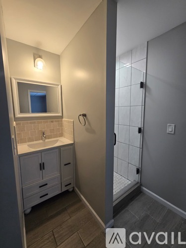 A bathroom with a sink, mirror, and cabinets.