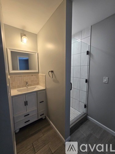 A bathroom with a sink, mirror, and cabinets.