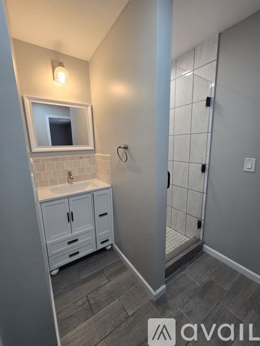 A bathroom with a sink, mirror, and cabinets.