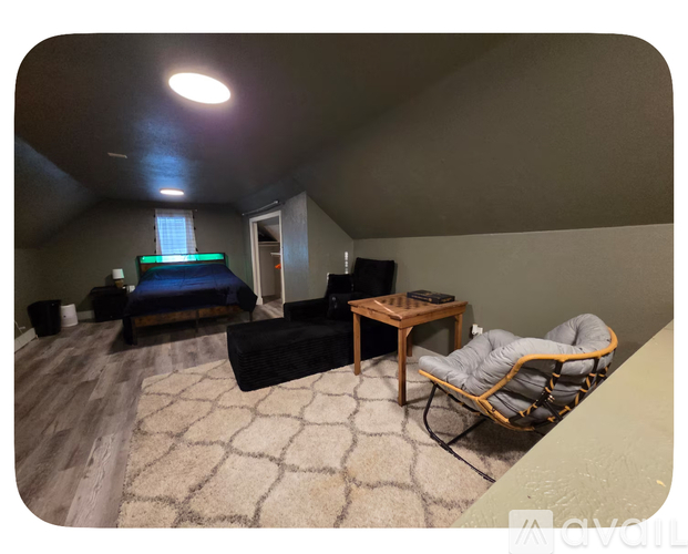 A room with a bed, a chair, and a table.