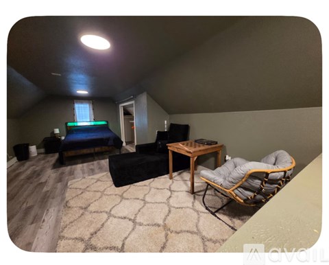 A room with a bed, a chair, and a table.