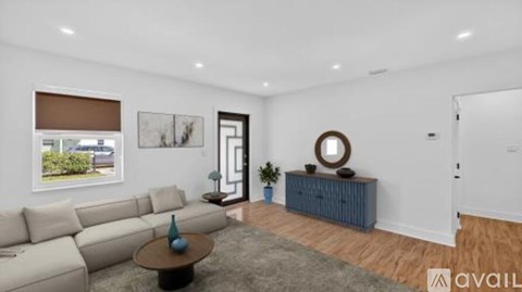A living room with a sofa, a coffee table, and a mirror on the wall.