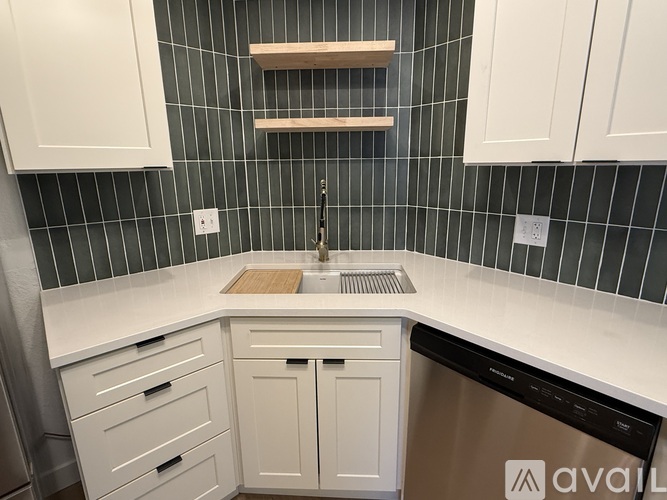 A kitchen with white cabinets and a black dishwasher.