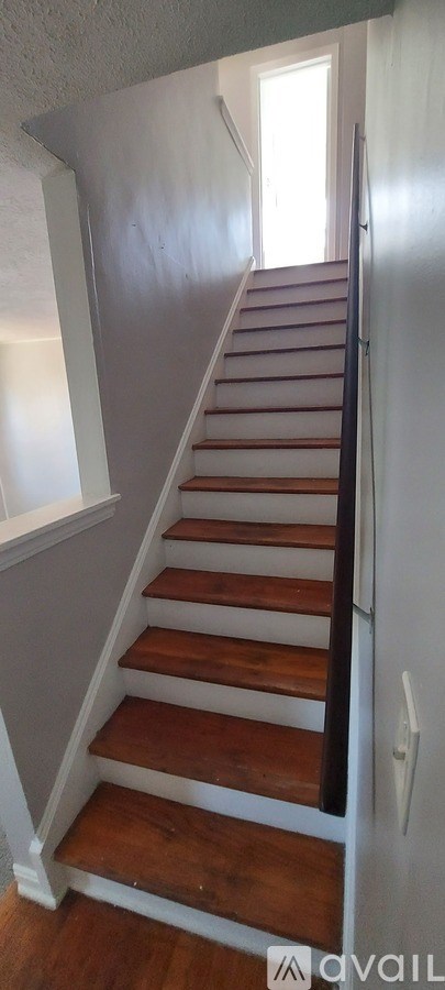 A staircase with wooden steps and white railings.