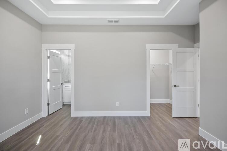 A spacious room with a wood floor and white walls.