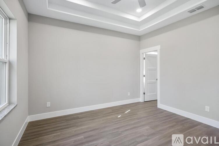 A room with a wooden floor and a ceiling fan.