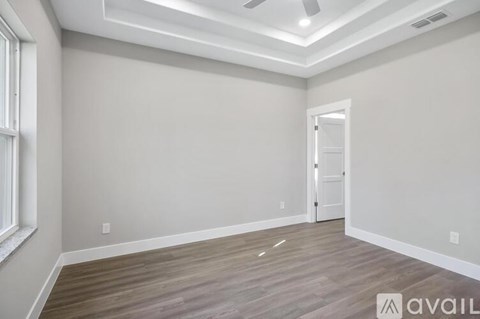 A room with a wooden floor and a ceiling fan.