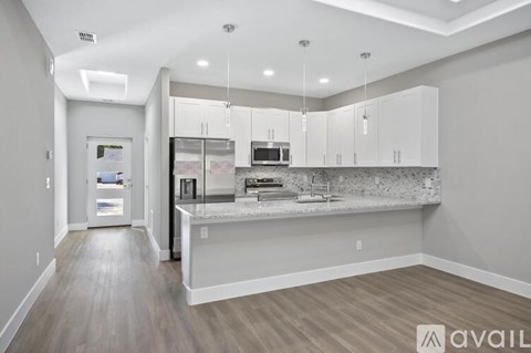 A modern kitchen with white cabinets and a marble backsplash.